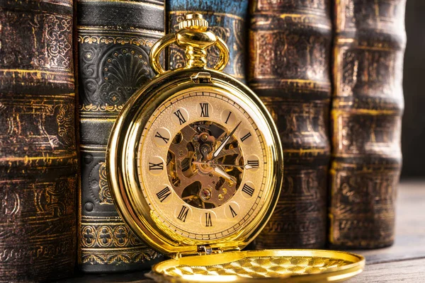 Starožitné hodiny na pozadí historických knih. Mechanické clo — Stock fotografie
