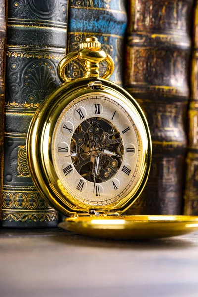 Antique clock on the background of vintage books. Mechanical clo — Stock Photo, Image