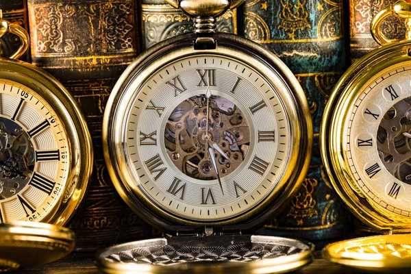 Antique clocks on the background of vintage books. Mechanical cl — Stock Photo, Image