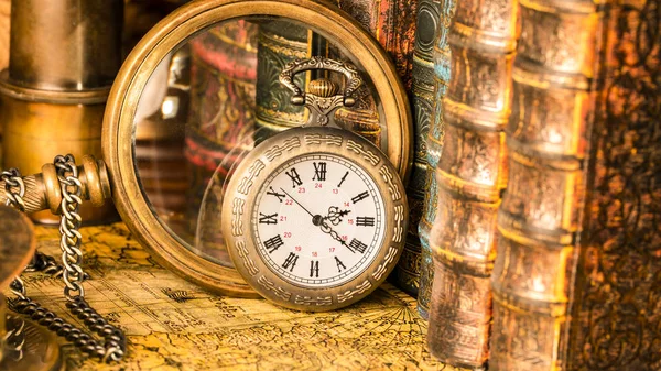 Antik klocka på bakgrunden av ett förstoringsglas och böcker. — Stockfoto