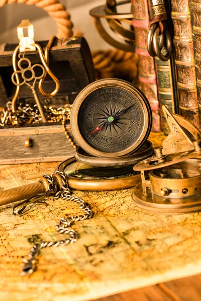 Antique compass on the background of a treasure chest with gold — Stock Photo, Image