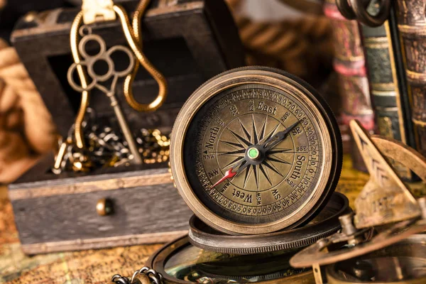 Bússola antiga no fundo de uma arca do tesouro com ouro — Fotografia de Stock