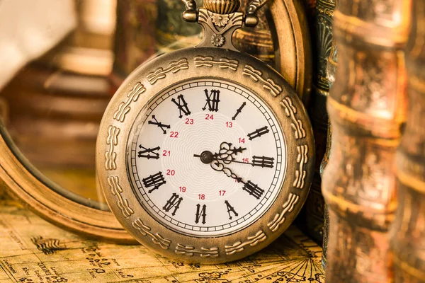 Arka planda bir büyüteç ve kitap antika saat.