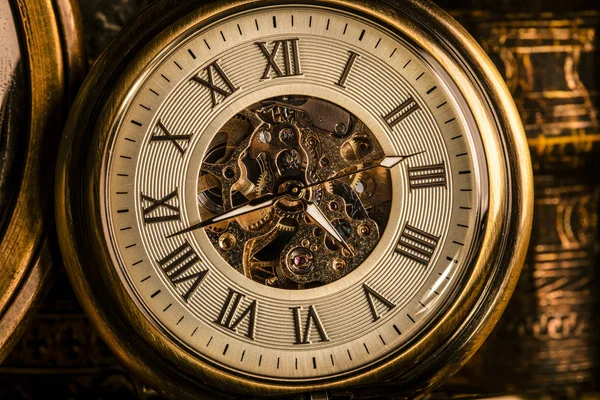 Relógio antigo no fundo de livros antigos. Clo mecânico — Fotografia de Stock