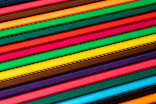 Colored pencils of all colors of the rainbow are on the table. A — Stock Photo, Image