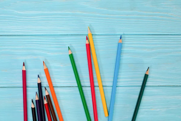 Colored pencils of all colors of the rainbow are scattered on th — Stock Photo, Image