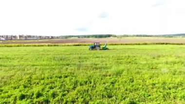 Traktör hardal alanında hasat üretir. Sarı çiçekler Greenfield. Drone hava fotoğrafçılığı.