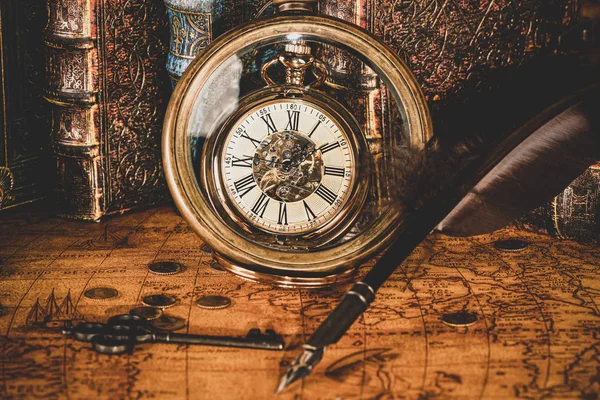 Horloge antique sur le fond d'une loupe et des livres . — Photo