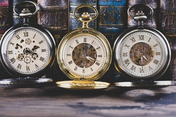 Антикварные часы на фоне старинных книг. Механический клон — стоковое фото