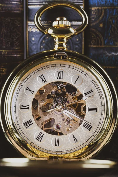 Relógio antigo no fundo de livros antigos. Clo mecânico — Fotografia de Stock