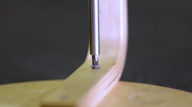 Tornavidalı bir adam vidaları sandalyenin bacağına vidalar. Ev işçiliği.