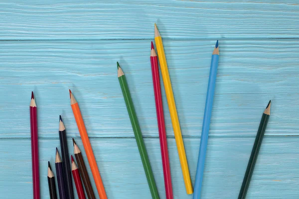 Colored pencils of all colors of the rainbow are scattered on th — Stock Photo, Image