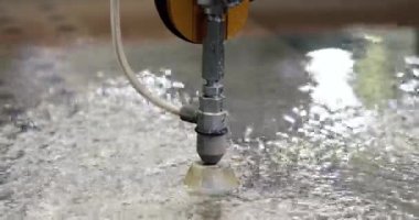 Su jeti ile metal kesmek için otomatik makine. Basınç altındaki su nesneleri keser.