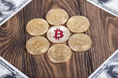 Kripto para birimi Bitcoin sikkesi. Altın sikke. 100 dolarlık banknotlar yalan