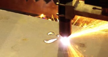 Metal işleme için otomatik programlanmış makine. Endüstriyel lazer makinesi çelik levha parçalarını kesiyor. Sıcaklık. Fabrikadaki üretim makinesinin çalışması sırasında kıvılcımlar.