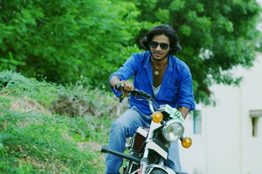 Genç adam bir motosiklet açık havada oturur