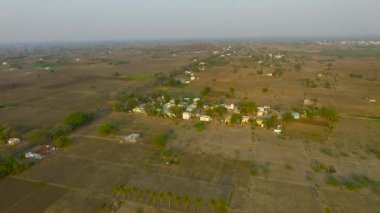 Güzel gün batımı küçük bir Hint köy çevresinde uçan.