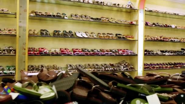 Winkelen. Close-up fel gekleurde modieuze lederen zomer schoenen en slippers op hoge hakken op glazen plank in de winkel, — Stockvideo