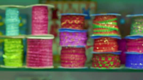 Ролики ткани и текстиля для продажи укладываются на полках в магазине — стоковое видео