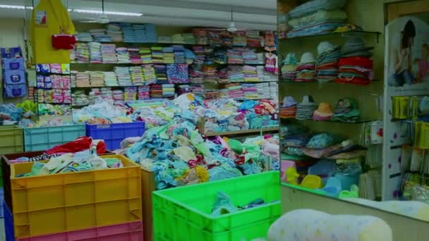 CHENNAI, INDIA - 05 DE ABRIL DE 2019: Interior de la tienda infantil. Bastidores con ropa para niños en la tienda de ropa para niños. (Variedad de productos de limpieza y cuidado en el hogar ) — Vídeos de Stock