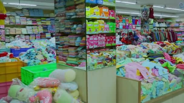 CHENNAI, INDIA - 05 DE ABRIL DE 2019: Interior de la tienda infantil. Bastidores con ropa para niños en la tienda de ropa para niños. (Variedad de productos de limpieza y cuidado en el hogar ) — Vídeos de Stock