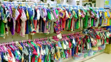 Çocuklar mağaza iç. Çocuk giyim mağazasında çocuk giysileri ve ayakkabı ekran duvar rafları ile raflar.