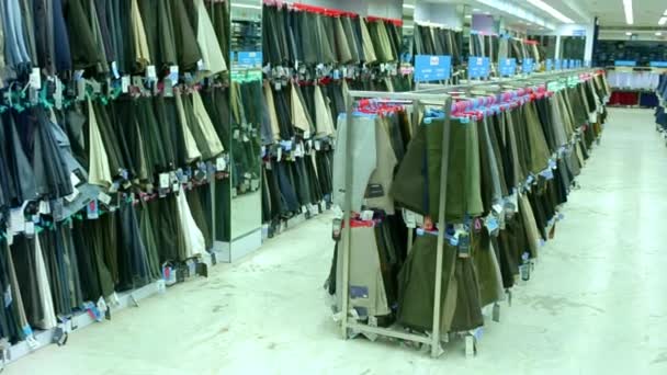 CHENNAI, INDIA - APRIL 05, 2019: beautiful luxury clothes store and shopping mall interior, Jeans hanging on hangers on the rack in the clothing store. — Stock Video