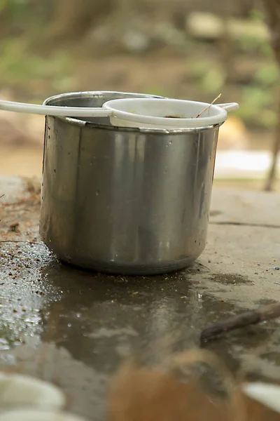 Closeup strainer with container and ground water leak reflection