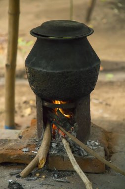Ahşap ocağı ya da Hindistan 'ın Tamil Nadu köyündeki kırsal bir Hint köyünde kırsal ocağı ile birlikte açık ateşte kaynar su.