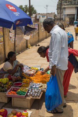 Chennai, Hindistan - 23 Ağustos 2019: Tanımlanamayan kadın sokak satıcısı tapınak festivalinde sokak dükkanlarında çeşitli ürünler satıyor.
