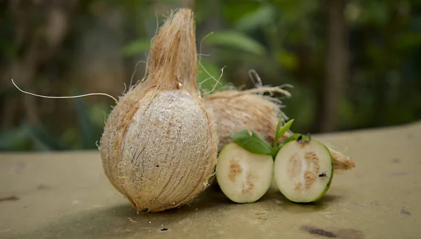 Coco marrom, goiaba de fatia com folha de banana verde no fundo da natureza . — Fotografia de Stock