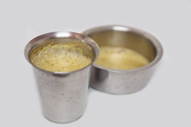 Indian filter coffee is famous coffee in steel cup. clipart