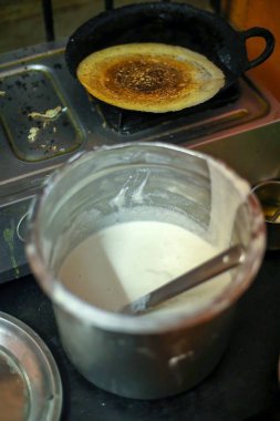 Dosa Hint yemeği. Kadınlar mutfakta Dosa pişiriyor ya da pişiriyor. Güney Hindistan vejetaryeni, geleneksel ve popüler kahvaltı.