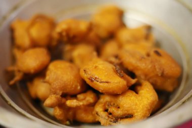 Ev yapımı Hint patatesi ve soğanlı pakoda veya Bhajji 'nin ünlü akşam atıştırmalıkları.