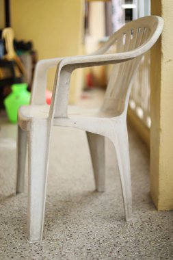 Evin önündeki beyaz plastik sandalye.