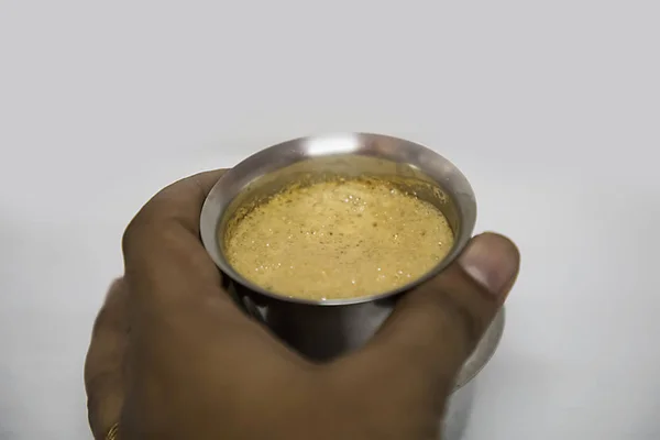 Ręce, które odbierają filiżankę kawy z południowoindyjskiego filtra w stalowych okularach - białe tło — Zdjęcie stockowe