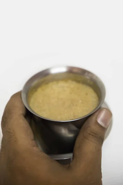 Ręce, które odbierają filiżankę kawy z południowoindyjskiego filtra w stalowych okularach - białe tło — Zdjęcie stockowe