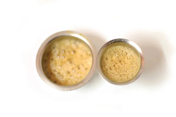 Top angle view of South Indian coffee served in steel glasses at white background — Stockfoto