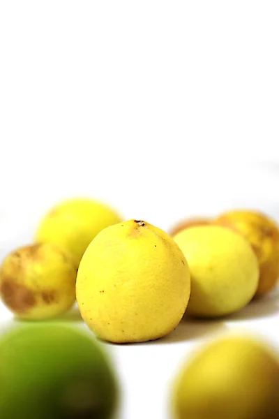 Beyaz arka planda lekeli limon ile taze ve yeşil limon — Stok fotoğraf