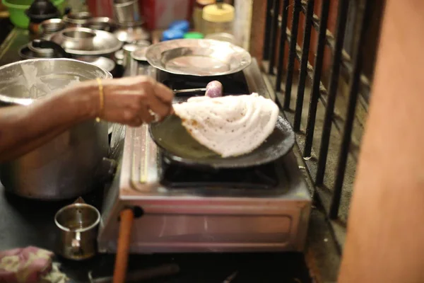 Ντόσα Ινδικό φαγητό. γυναίκες χέρι μαγείρεμα ή την κατασκευή της Dosa στην κουζίνα, Ινδία. Νότια ινδική χορτοφάγος, παραδοσιακό και δημοφιλές πρωινό. — Φωτογραφία Αρχείου