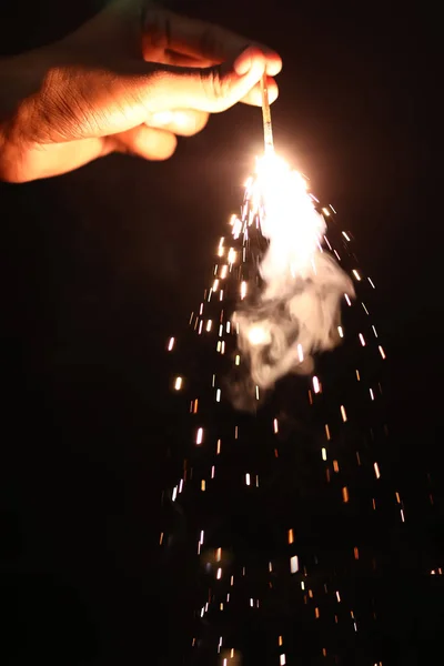 Mano que sostiene la explosión ardiente de Sparkler en un fondo negro en la noche, fiesta del acontecimiento de la celebración de vacaciones , —  Fotos de Stock