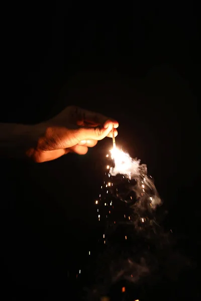 Ręczne trzymanie płonący Blast Sparkler na czarnym tle — Zdjęcie stockowe