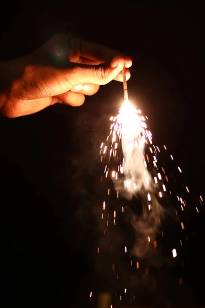 Mão segurando queima Sparkler explosão em um fundo preto à noite, festa do evento de celebração do feriado , — Fotografia de Stock