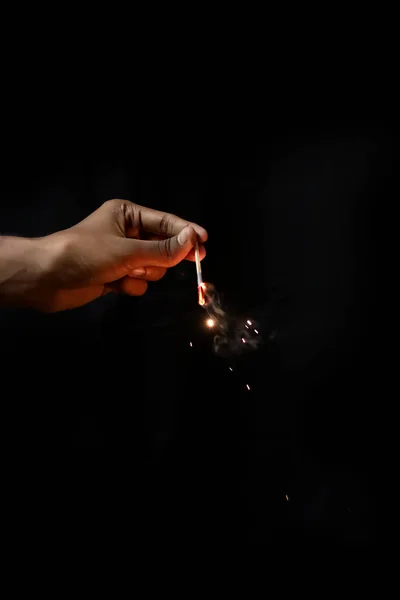 Mão segurando queima Sparkler explosão em um fundo preto — Fotografia de Stock