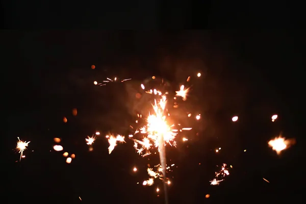 Mano sosteniendo la explosión Sparkler ardiente sobre un fondo negro —  Fotos de Stock