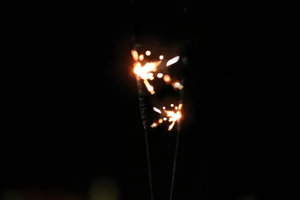 Mão segurando queima Sparkler explosão em um fundo preto — Fotografia de Stock