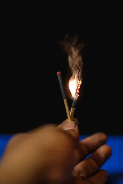 Mão segurando sparklers matchstick sobre fundo preto — Fotografia de Stock