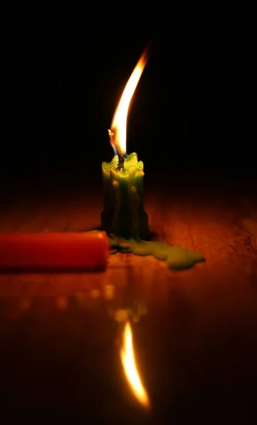 Uma vela de luz queimando brilhantemente no fundo preto. — Fotografia de Stock