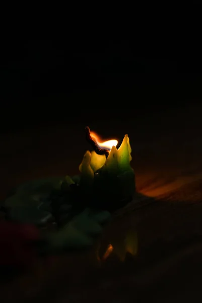 Uma vela de luz queimando brilhantemente no fundo preto. — Fotografia de Stock