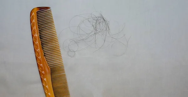 Woman losing hair on hairbrush in white background, soft focus